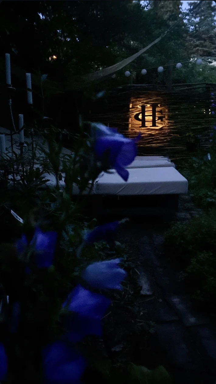 Garden pathway and lit HG sign at dusk